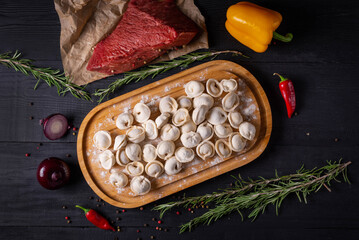 semi-finished products, dumplings with ground beef on a black background