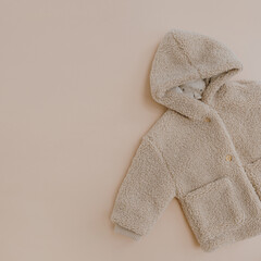 Warm winter children's jacket. Baby wear on neutral beige background. Fashion Scandinavian...
