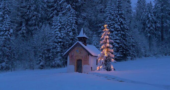 Beleuchteter Weihnachtsbaum mit Kapelle bei Nacht, Winterlandschaft, Bayern, Deutschland