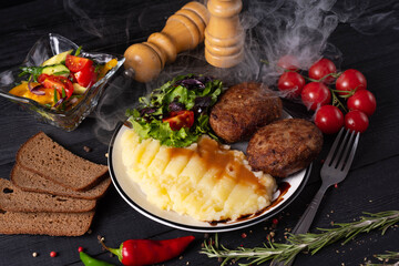 fried meat patties with mashed potatoes, on a black background