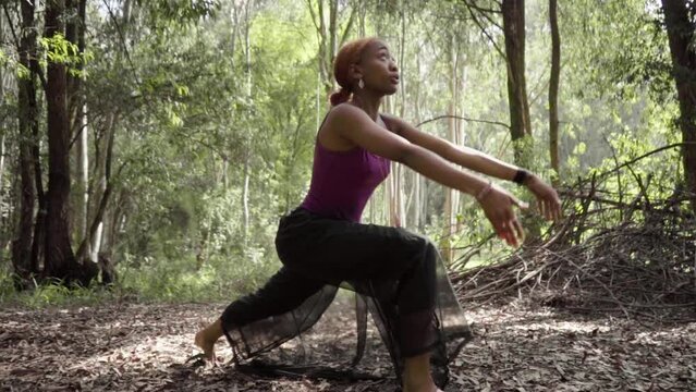 young woman doing yoga in the forest