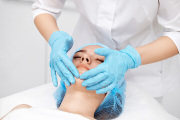 Obraz na płótnie Canvas young beautiful woman receiving facial massage. spa