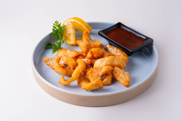 fried fish with tomato sauce on a white background