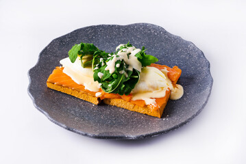 breakfast. bread with red fish poured with sauce and arugula leaves on a white background