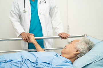 Obraz premium Doctor touching hands Asian senior or elderly old lady woman patient with love, care, encourage and empathy at hospital.