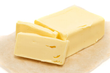 Pieces of butter lie on parchment paper on a white background