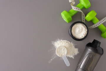 Nutrition for muscle growth concept. Top view composition of whey protein in jar, sport shaker...