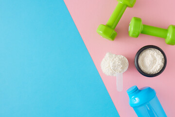 Fitness diet concept. Top view composition of whey protein in jar with shaker and dumbbells on...