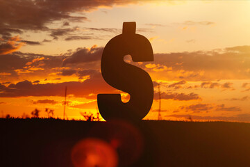 Dollar money sign at sunset in the rays of the setting sun. Sunset currency. Devaluation of money.