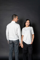 Young couple wearing white blank shirt doing a pose with a black background