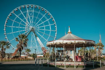 Papier Peint photo Parc dattractions Ferris wheel and empty rides in old vintage amusement park without people.