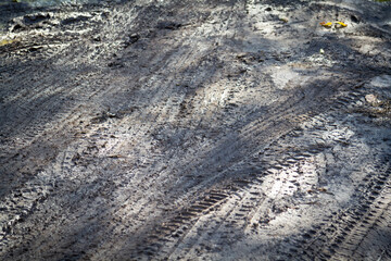 Puddles and mud after heavy rain. Flooded area with traces of cars.