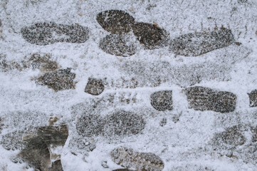 Footprints on white snow lying on the road, asphalt in the city in winter. Photography, texture.