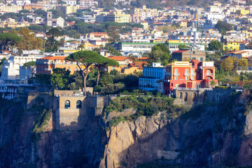 Fototapeta na wymiar Rocky Coast and Homes in Touristic Town, Sorrento, Italy. Amalfi Coast. Sunny Evening