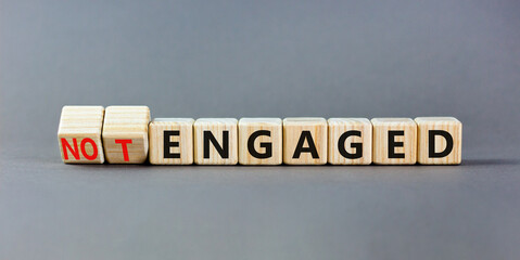 Engaged or not symbol. Concept words Engaged and Not engaged on wooden cubes. Beautiful grey table grey background. Business engaged or not engaged concept. Copy space.