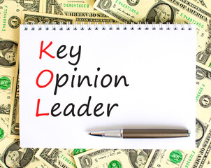 KOL key opinion leader symbol. Concept words KOL key opinion leader on white note on a beautiful background from dollar bills. Business KOL key opinion leader concept. Copy space.