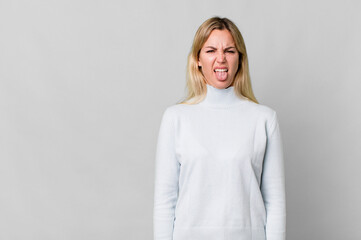 caucasian blonde woman feeling disgusted and irritated and tongue out. copy space concept