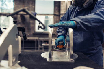 Factory worker polishing a metal part