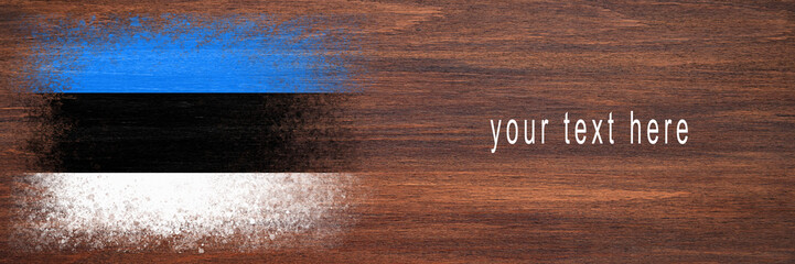 Flag of Estonia. Flag is painted on a wooden surface. Wooden background. Plywood surface. Copy space. Textured background