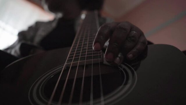 close up of a woman's fingers strumming a guitar