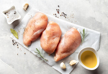 Raw chicken breast with spices on a light background top view © kucherav