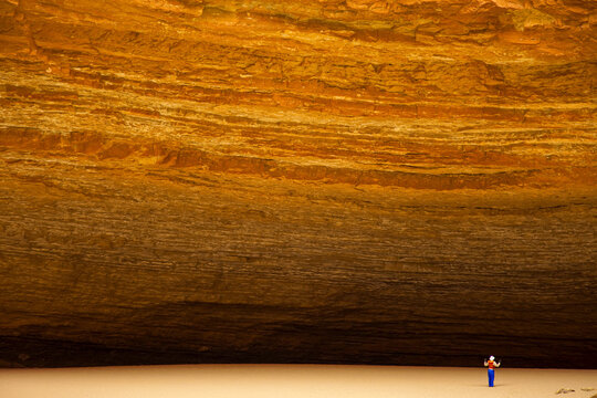 Person dwarfed by massive Redwall Cavern on the Colorado River.