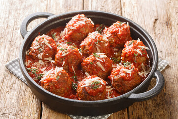 Polpette meatballs with parmesan stewed in a rich tomato sauce close-up in a frying pan on the table. Horizontal