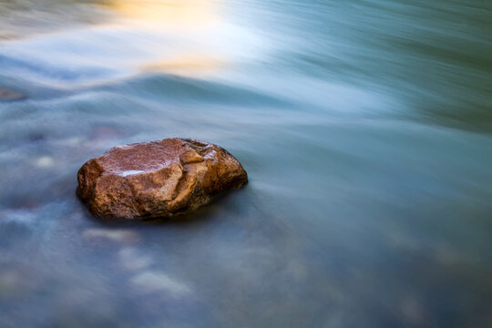Boulder and flowing water, Colorado River, Grand Canyon, Arizona.