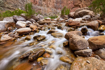 A fast moving creek flows over desert rocks.