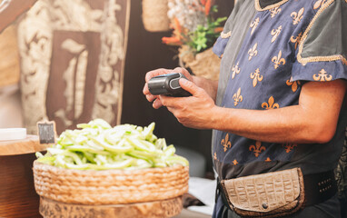 Seller holding dataphone in medieval steet market in medieval clothes.