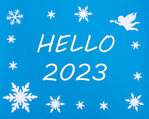 Naklejka na ściany i meble New Year's greeting card. The text HELLO 2023 on a blue background with Christmas snowflakes, a white angel.