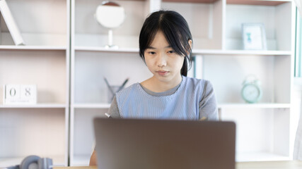 Young Asian woman greets his friends and teachers in a live video with a smile on his face, Online communication , Stay home, New normal, VDO Call, Social distancing, Internet learning.