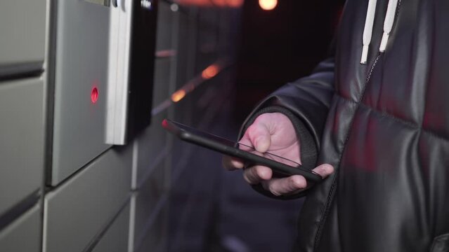 Close up man scans QR Code on mobile smartphone for opening box with him purchase. collecting parcel from shopping post locker. Contactless receiving and sending of parcels service