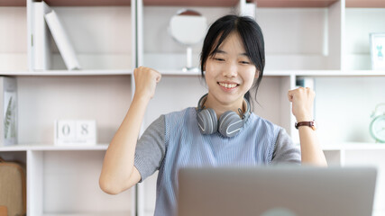 Joyful, Surprised or shocked Asian woman raised her arms all the way because she did a good job the boss gave her a big bonus making her very happy, Raise your hand, Smiling and screaming for success.