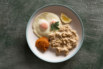 Healthy breakfast oatmeal and fried eggs on a large platter, top view, healthy eating