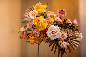 Beautiful flower composition with dry palm leaves, gerberas, white and yellow roses, carnations. Autumn arrangement for decorating party, home or table. Could be a gift on display or decoration