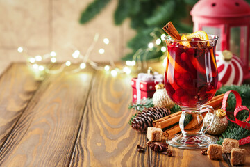Christmas hot mulled wine. Glasses of mulled wine with aromatic spices cinnamon, anise, sugar and fir tree branches with bokeh and decorations. Traditional Xmas festive drink. Winter Christmas drink.