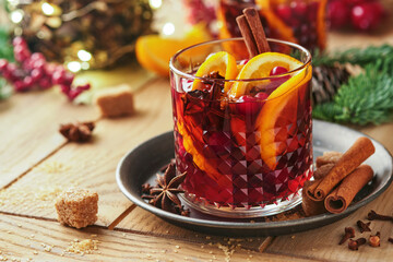 Christmas hot mulled wine. Glasses of mulled wine with aromatic spices cinnamon, anise, sugar and fir tree branches with bokeh and decorations. Traditional Xmas festive drink. Winter Christmas drink.