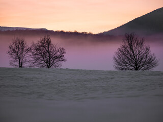 Fog and sunset in the mountains in winter