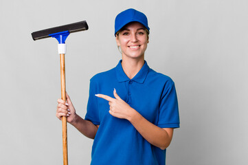 caucasian blonde woman smiling cheerfully, feeling happy and pointing to the side. windows washer...