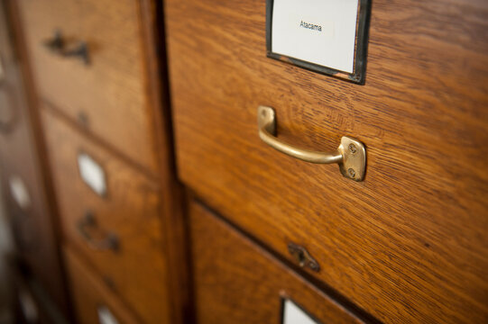 Close up of the wooden drawers, metal handle and label on a file cabinet; Lincoln, Nebraska, United States of America