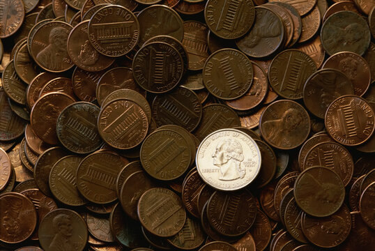 Single American quarter on a pile of American pennies; United States of America