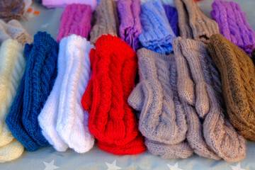 Fototapeta na wymiar knitted warm gloves for winter in different colors. handicraft