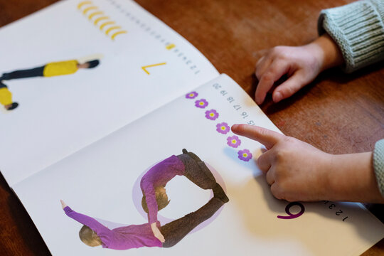 Young child studying numbers in her book during lockdown.