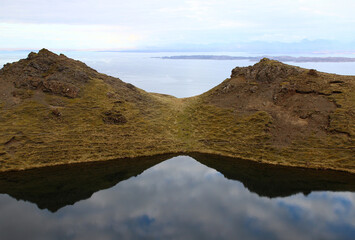 Fototapeta na wymiar 2 small hills overlook a loch (Isle of Skye, Scotland).