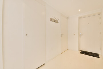 an empty room with white walls and floorboards on the wall, there is a door leading to another room