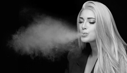 Beautiful sexy woman blowing smoke. Monochrome studio portrait isolated on black with copy space