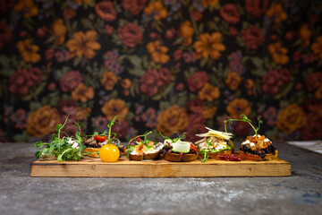 assorted bruschetta with different flavors on a wooden board
