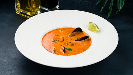 Thai soup Tom yum with mussels, lime, herbs and chili peppers.