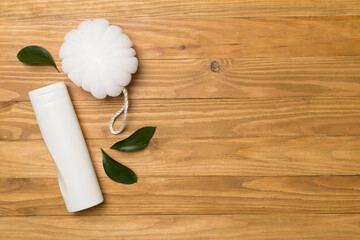 Shower gel with washcloth on wooden background, top view